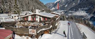 Außenansicht Bellevue Alm neben Skipiste Winter