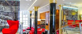 Hotel Lobby mit roten Akzenten und goldenen Säulen