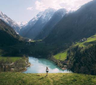 Bergbach zwischen Alpenpanorama mit wandernder Frau